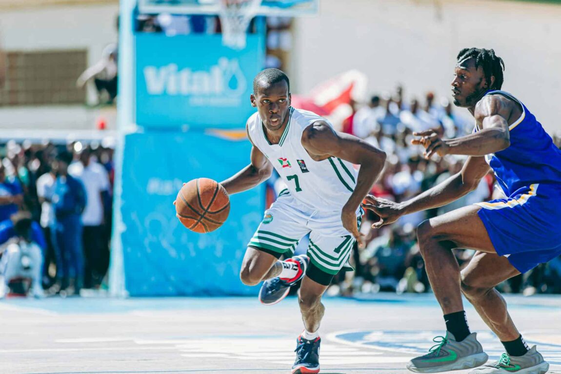 ALT here: Young basketball player dribbling past defender during game.